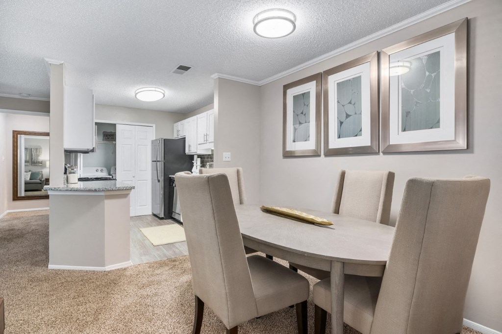 Carpeted dining room with overhead lighting adjacent to kitchen at Summerchase at Riverchase in Hoover, Alabama