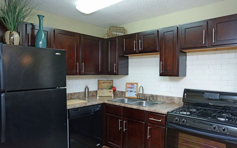 a kitchen with black appliances and brown cabinets