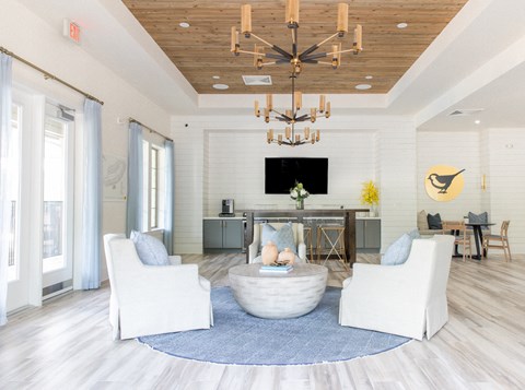 a living room with white furniture and a large chandelier