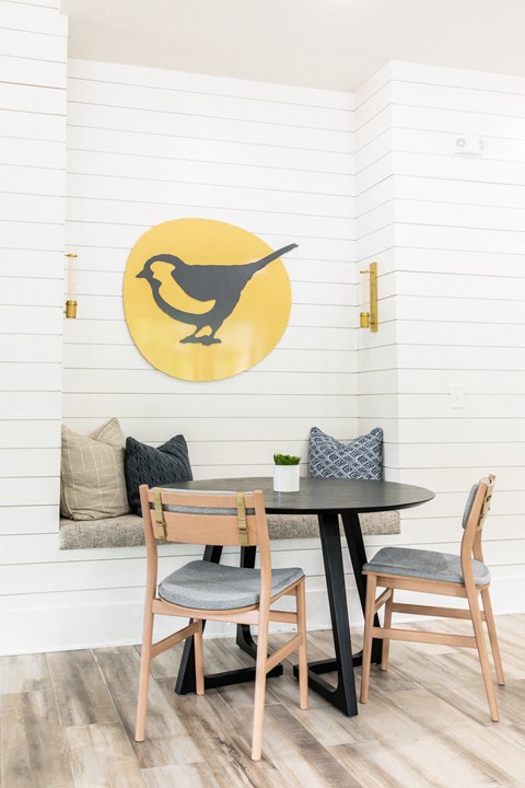 a dining room with a table and chairs and a bird on the wall