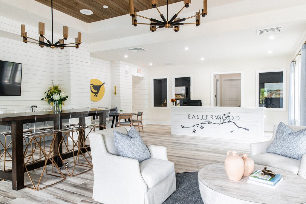a living room with white furniture and a dining room with a table and chairs