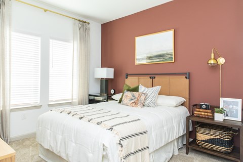a bedroom with a white bed and a red wall