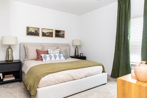 a bedroom with a bed and green curtains