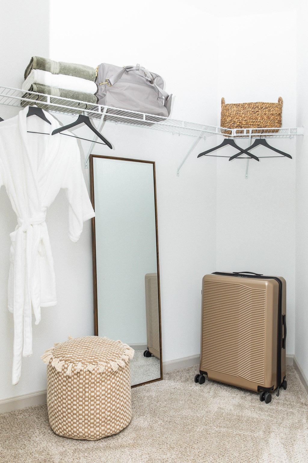 a closet with a mirror and a wardrobe with clothes and a basket