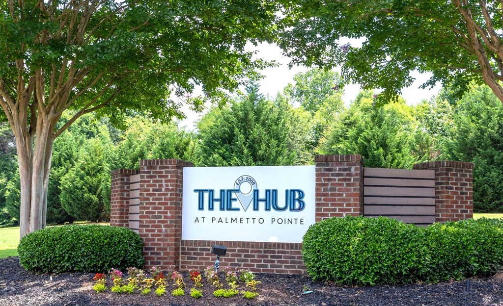 the hub at palmetto pointe sign in front of brick wall and trees