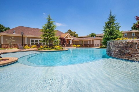 a large swimming pool with a house in the background