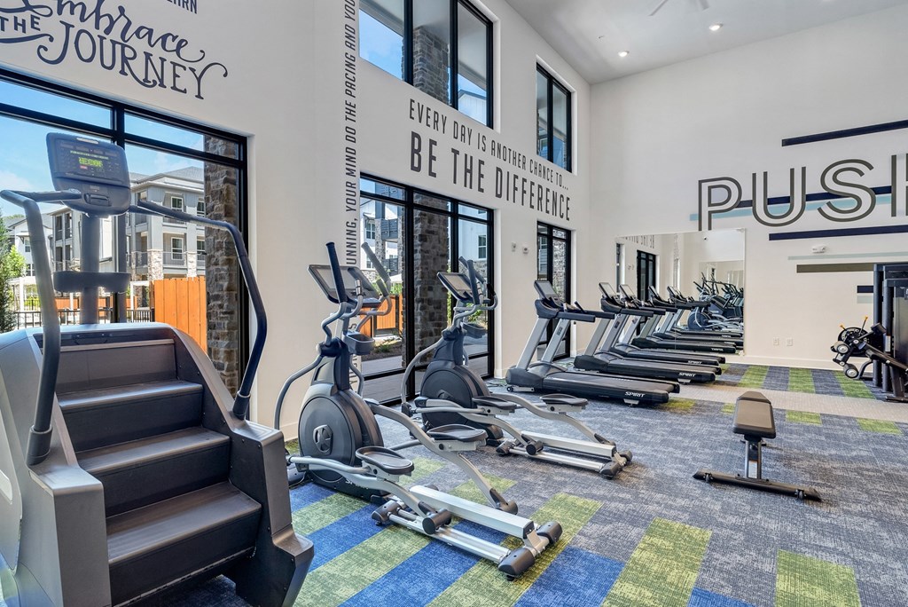 a gym with treadmills and stairmaster at Tapestry Overbrook in McDonough, Georgia