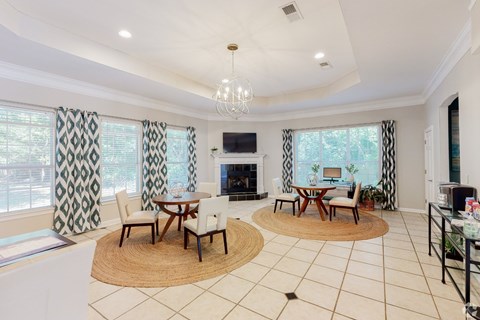 A spacious living room with a fireplace and a dining table set up.