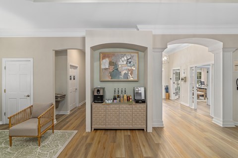A living room with a wooden floor and a large painting on the wall.