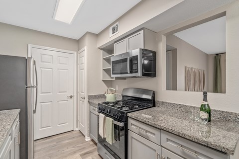 A kitchen with a black stove top oven and a black refrigerator.