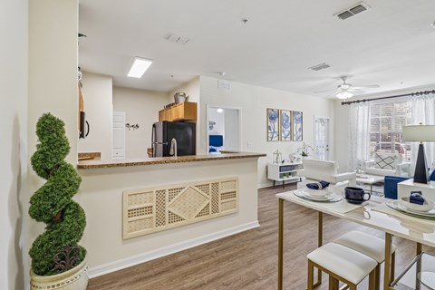 A well-lit kitchen with a dining table set for two.