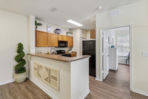 A kitchen with a white counter and wooden cabinets.