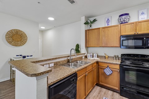 A kitchen with wooden cabinets and a granite countertop.