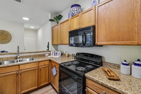 A kitchen with wooden cabinets and granite countertops.