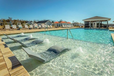 a resort style pool with chaise lounge chairs and a screened gazebo at Anthem Apartments and Cottages in Huntsville, Alabama