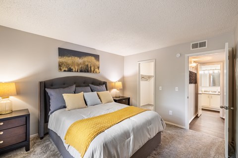 A bedroom with a large bed and a painting on the wall.