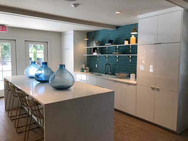 a kitchen with a long counter with blue vases on it