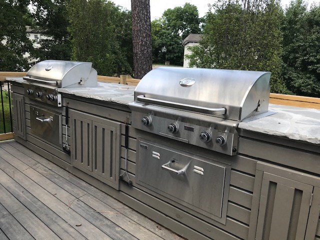 a stainless steel grill and bbq area on a deck