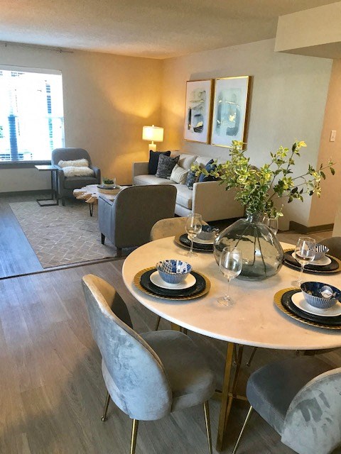 a living room and dining room with a table and chairs