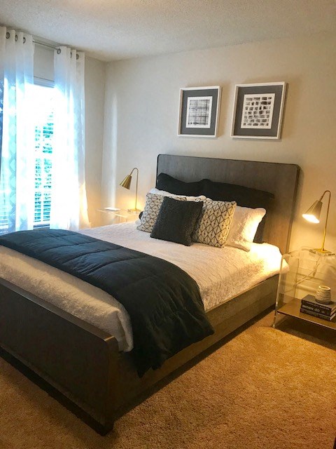 a bedroom with a bed and two lamps and a window