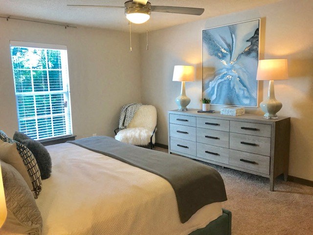 a bedroom with a bed and a dresser and a window