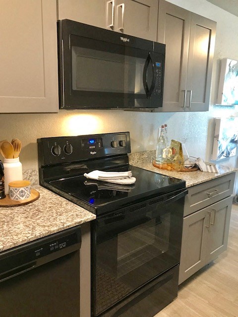 a kitchen with a black stove and a microwave