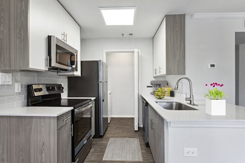 a kitchen with white counter tops and stainless steel appliances