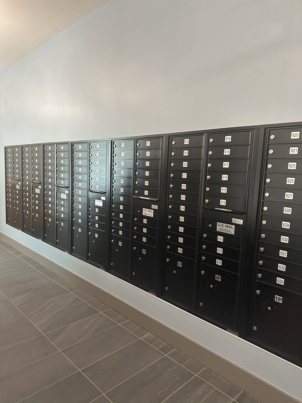 a row of metal lockers with white labels