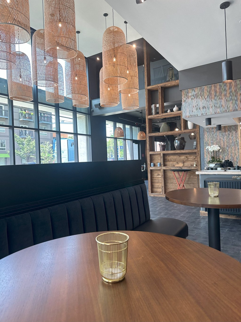a dining room with a wooden table and black booths