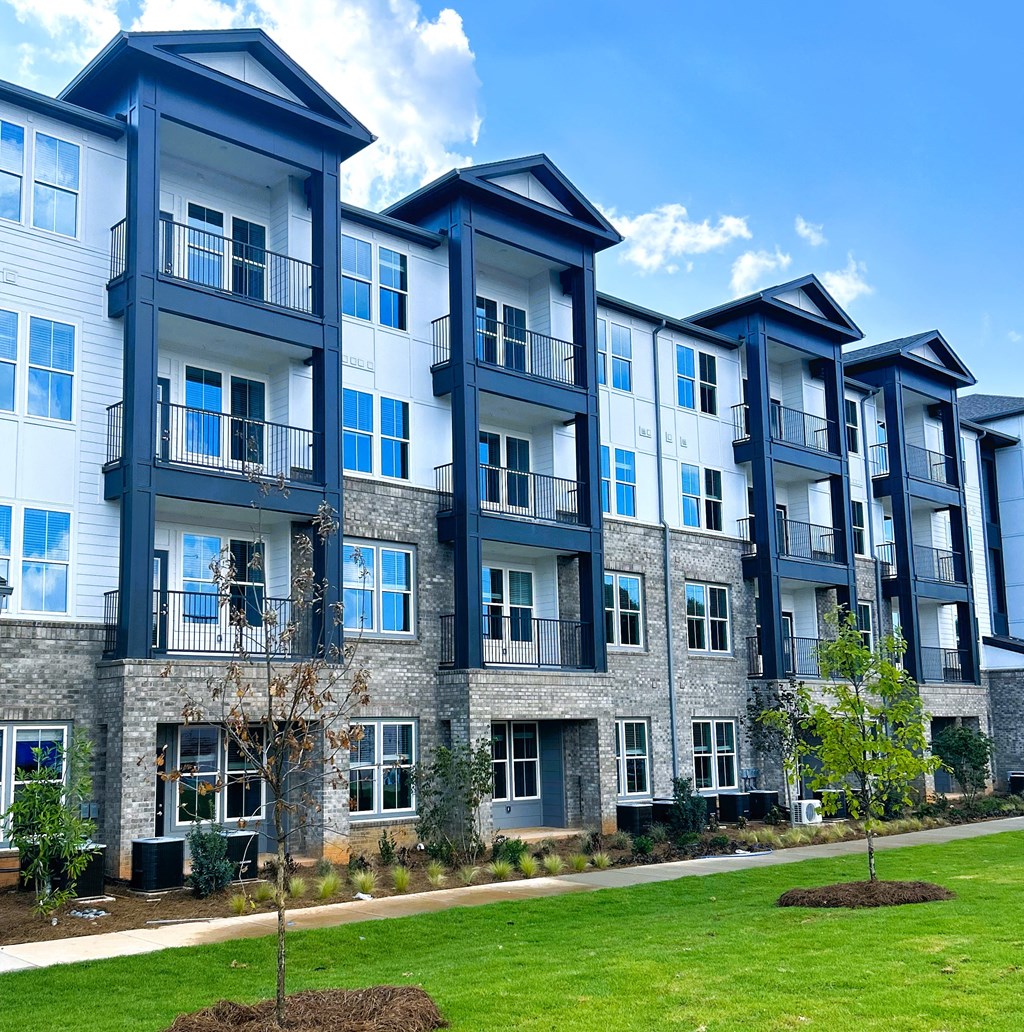 an apartment building with green grass in front of it