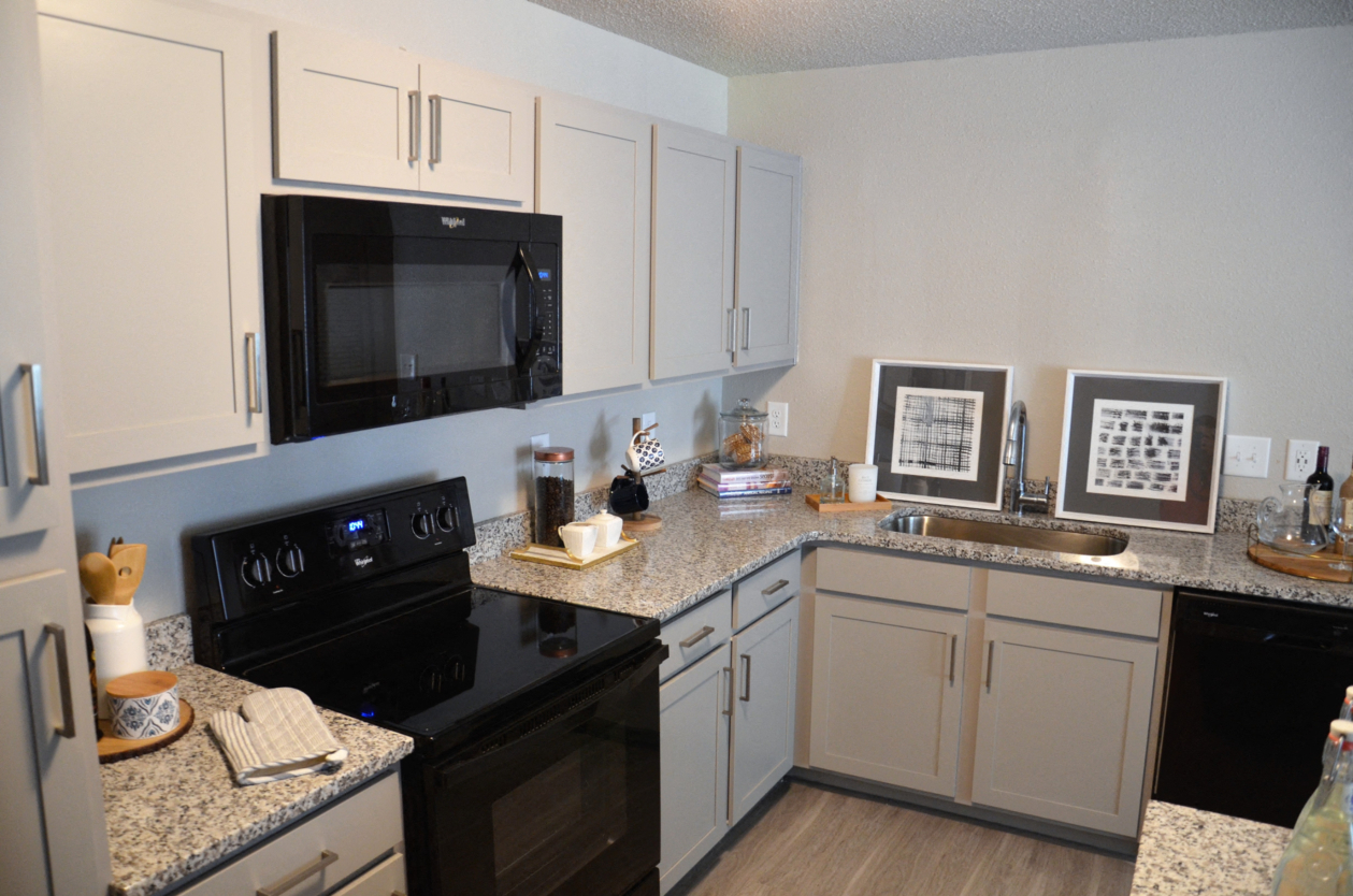 a kitchen with black appliances and granite counter tops