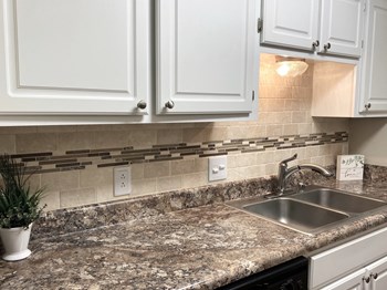 wood floors at Malibu at Martin Apartments in Huntsville, Alabama White kitchen cabinets and granite countertops at Malibu at Martin Apartments in Huntsville, Alabama