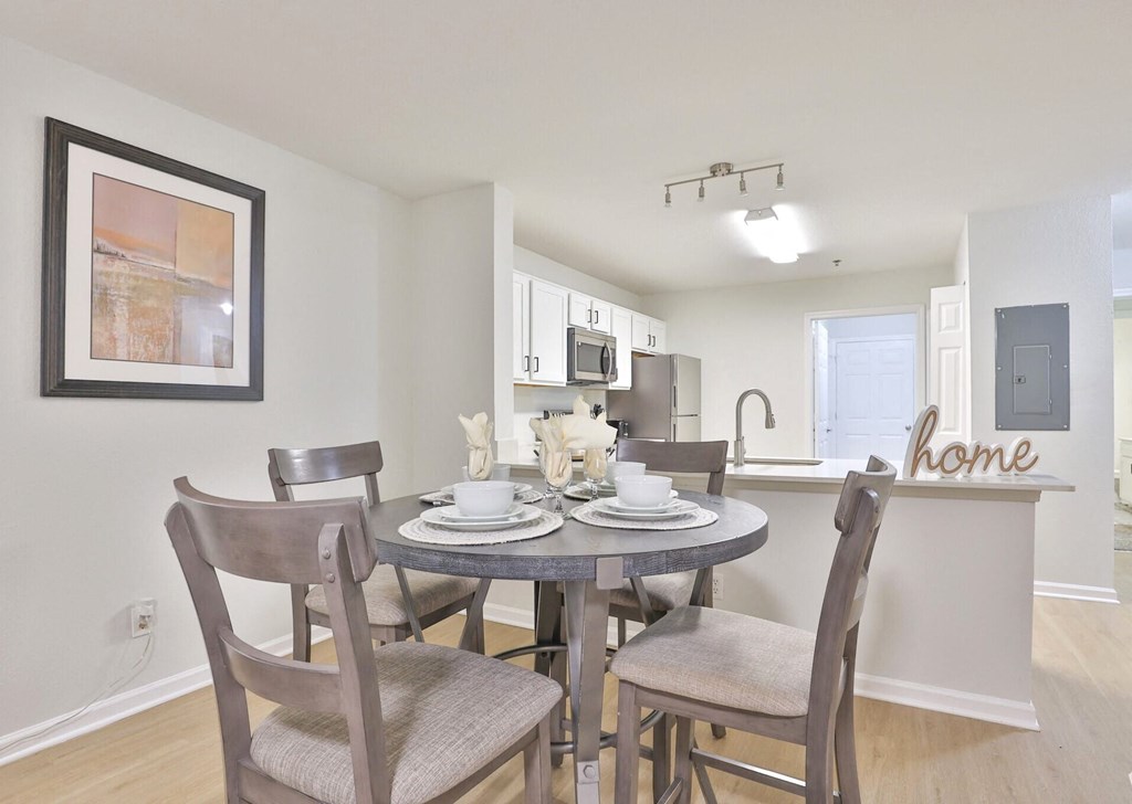 a dining room and kitchen with a table and chairs