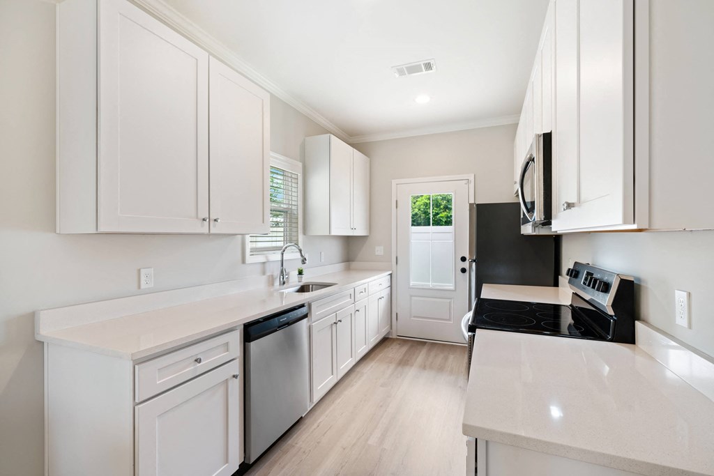 a large white kitchen with white cabinets and white counter tops