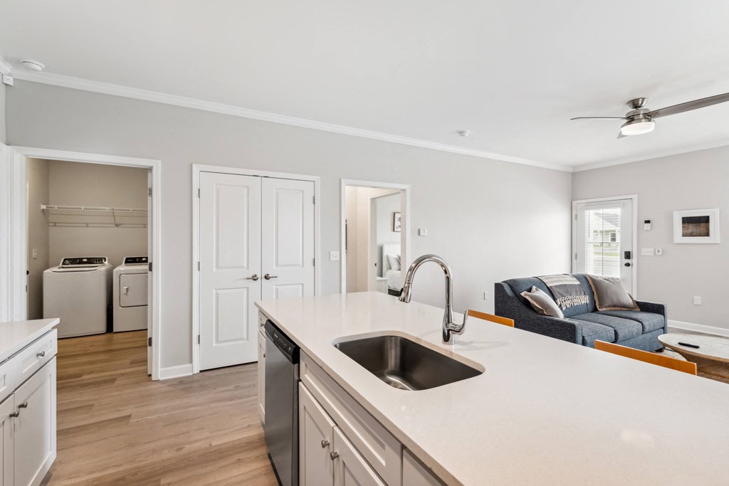a kitchen with an island and a sink and a living room with a couch