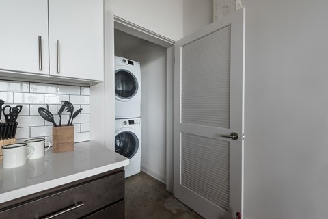 a kitchen with a washer and dryer and a door to the laundry room