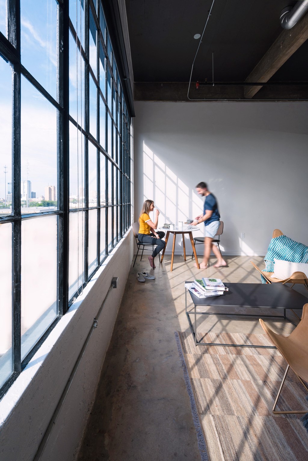 people sitting at a table in a room with large windows