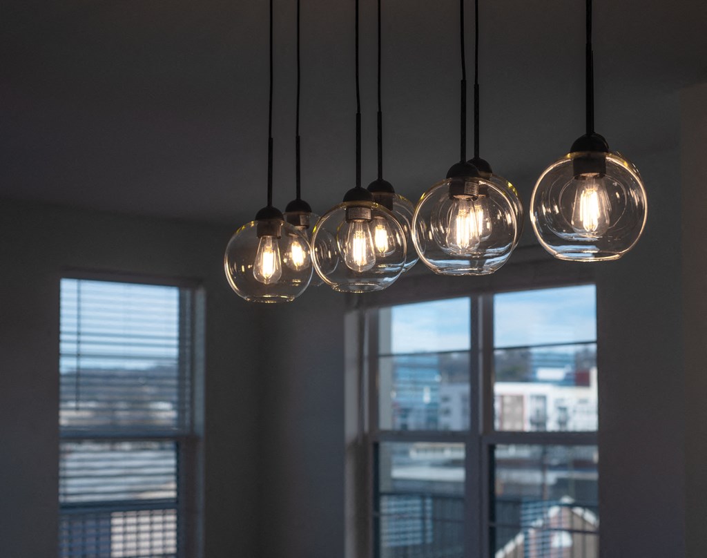 a row of lights hanging from a ceiling with windows at Artisan Flats in Birmingham, AL