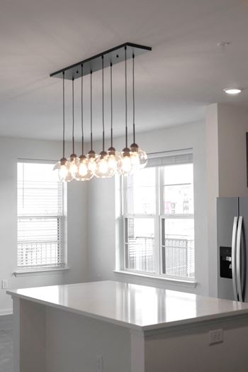 a kitchen with a counter top and a chandelier at Artisan Flats in Birmingham, AL