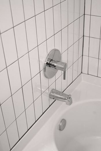 a white sink in a white tiled bathroom at Artisan Flats in Birmingham, AL