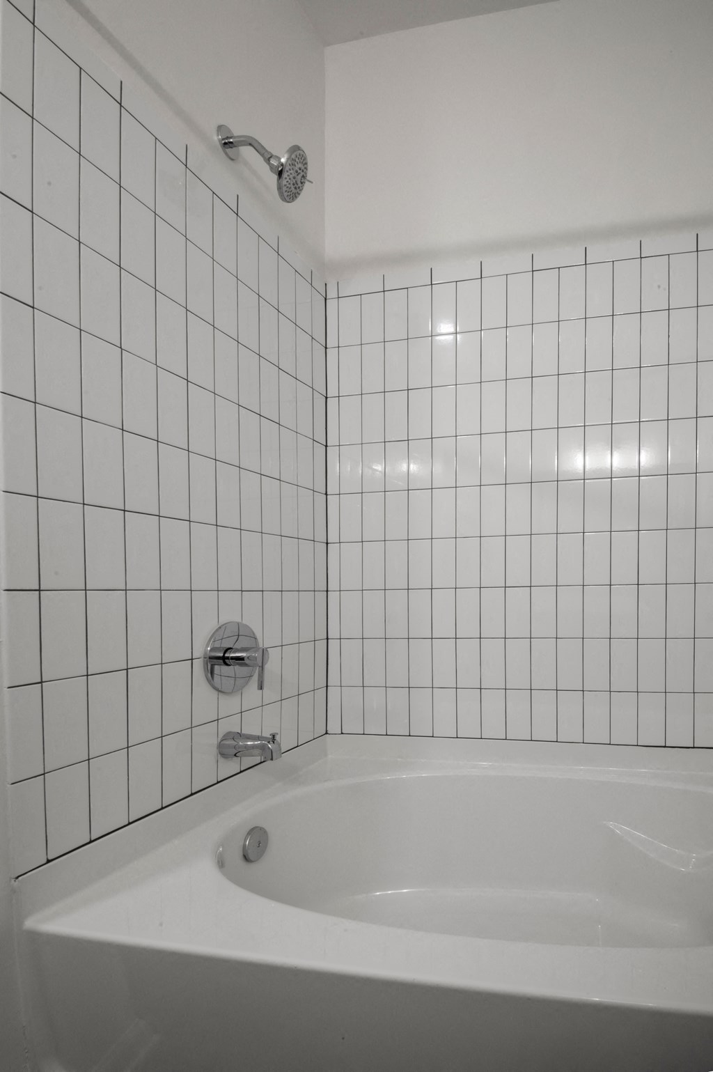 a white tiled bathroom with a tub and a shower at Artisan Flats in Birmingham, AL
