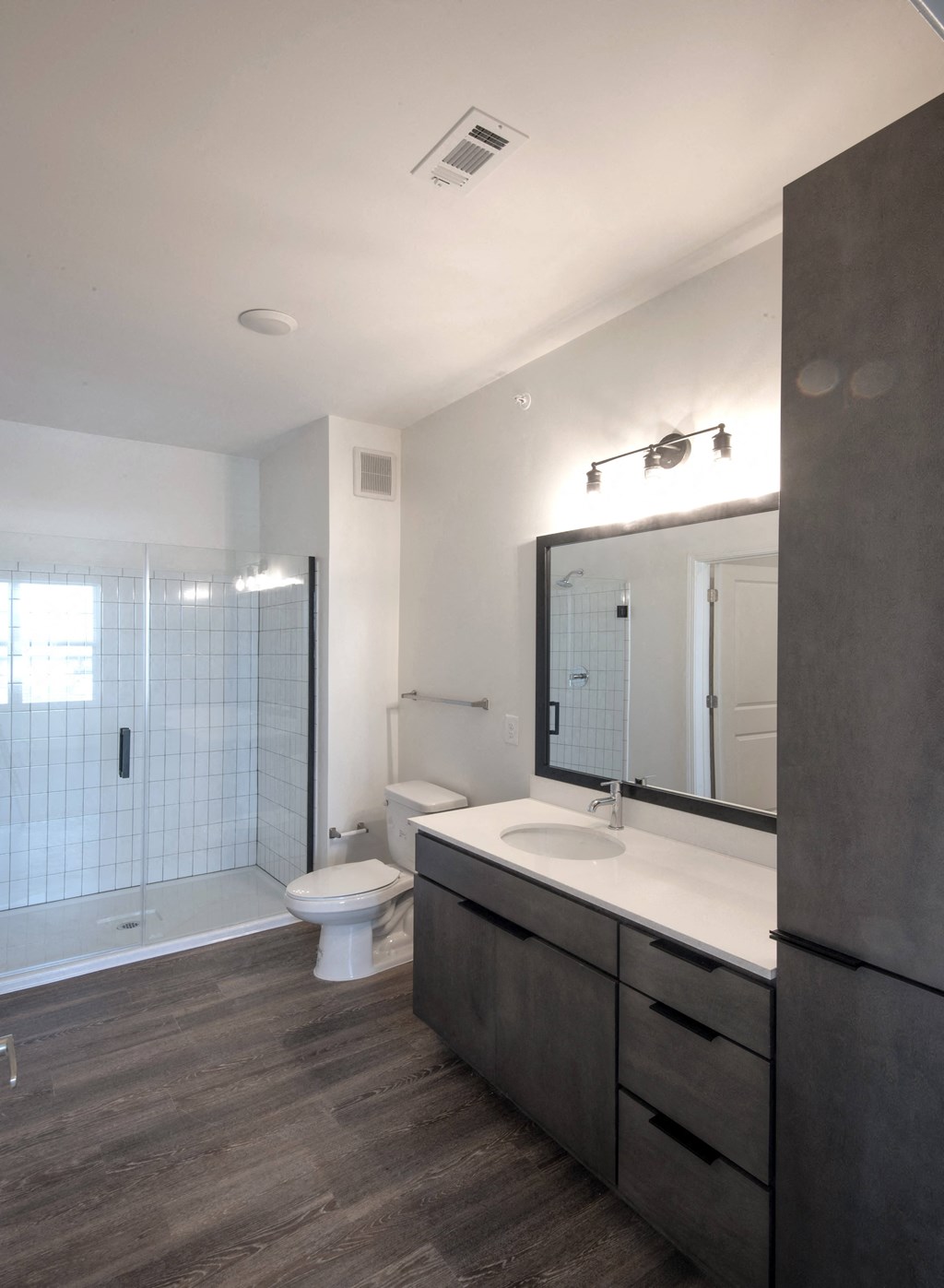 a bathroom with a toilet and a sink and a mirror at Artisan Flats in Birmingham, AL