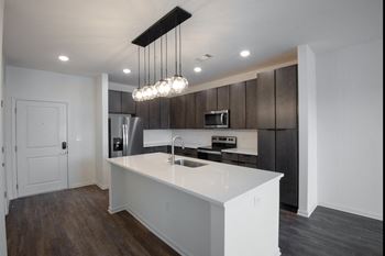 a kitchen with a large white island with a sink at Artisan Flats in Birmingham, AL