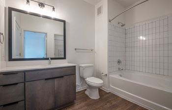 a bathroom with a toilet and a tub and a sink at Artisan Flats in Birmingham, AL