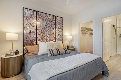 A bedroom with a large bed and a floral wallpaper.
