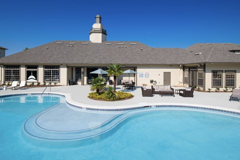 A large building with a pool in front of it.