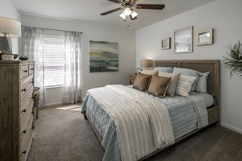 A bedroom with a large bed and a ceiling fan.