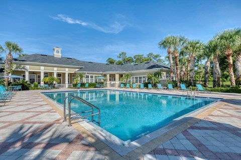 A large swimming pool with a building in the background.