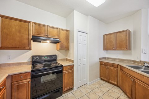 a kitchen with wooden cabinets and a stove and a sink