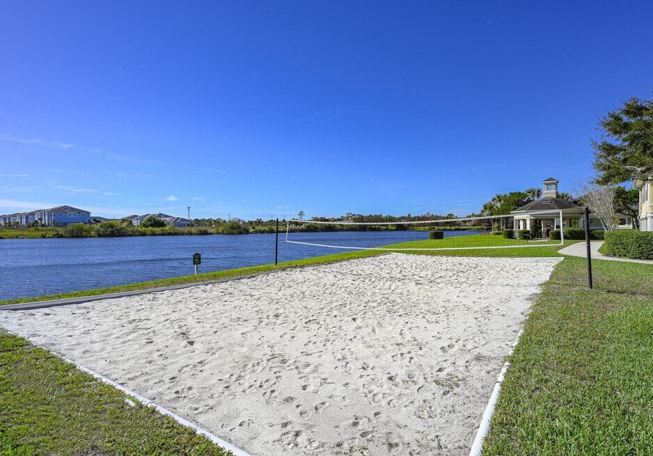 a sandy beach next to a body of water